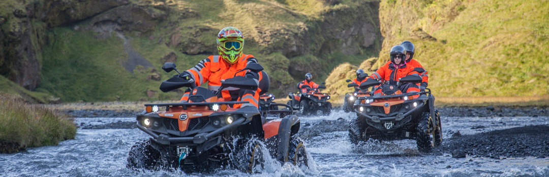 ATVs crossing a river in Iceland's rugged nature.