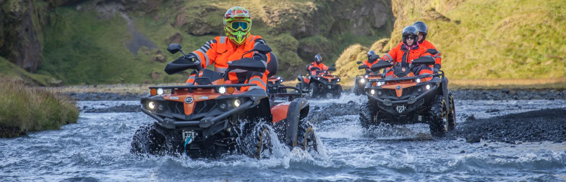 People on ATVs crossing a creek in Iceland.