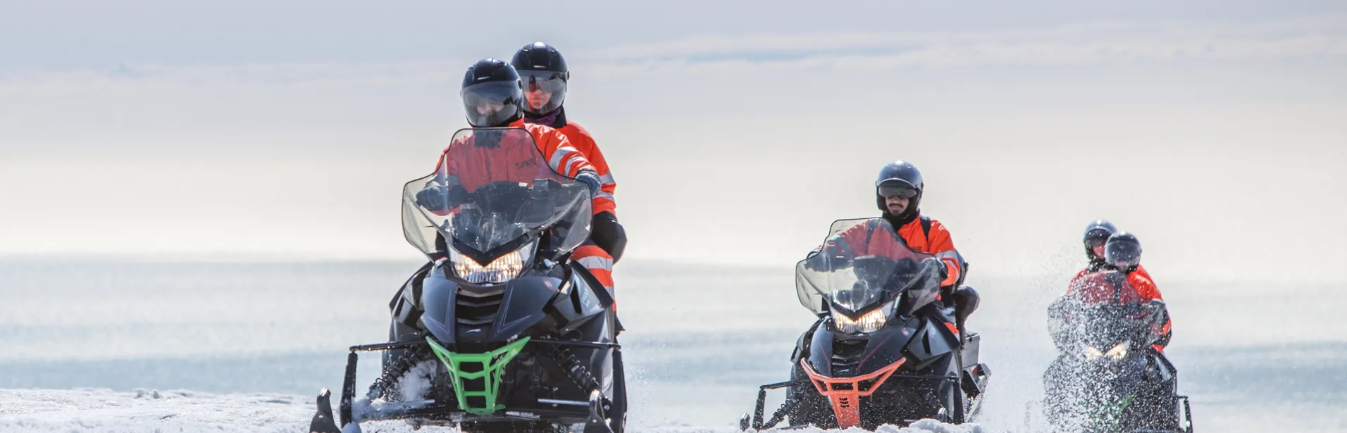 A group riding snowmobiles on a glacier in Iceland.