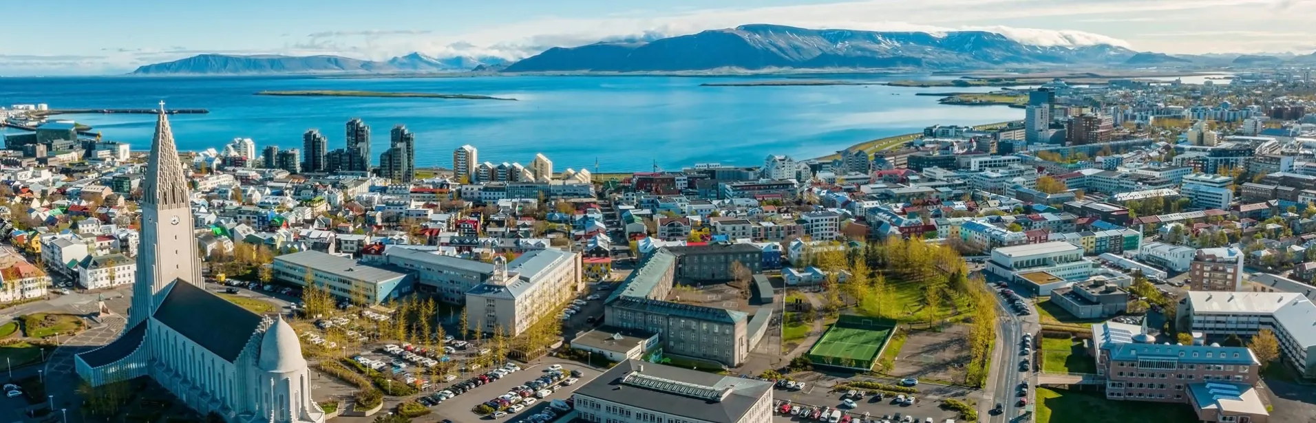 Aerial view of Reykjavik with Hallgrímskirkja and the ocean in the background.